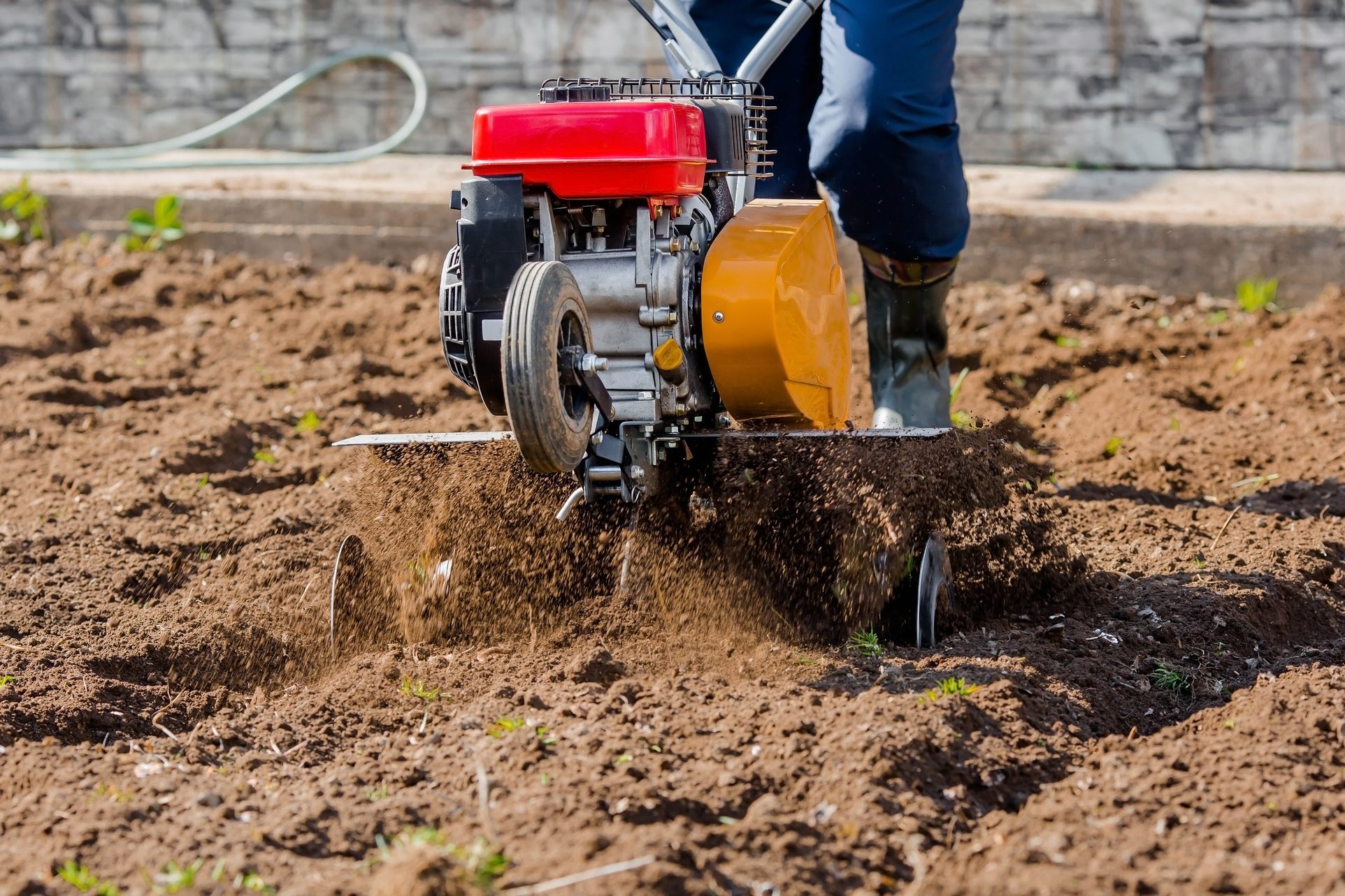 Farmer plows the land with a cultivator