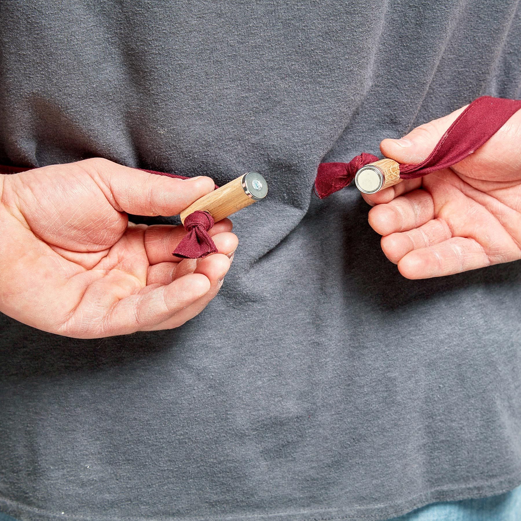 close up of hands using magnets to tie apron behind their back