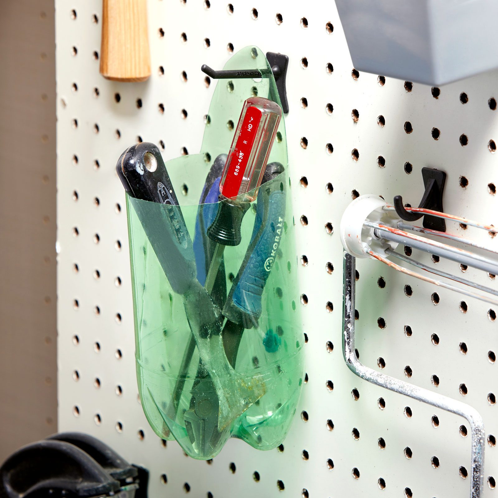 recycled bottle cut to hold tools in a workshop