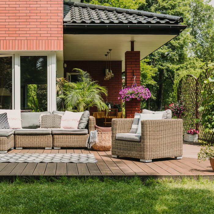 Elegant floating deck with patio furniture in a backyard with green grass
