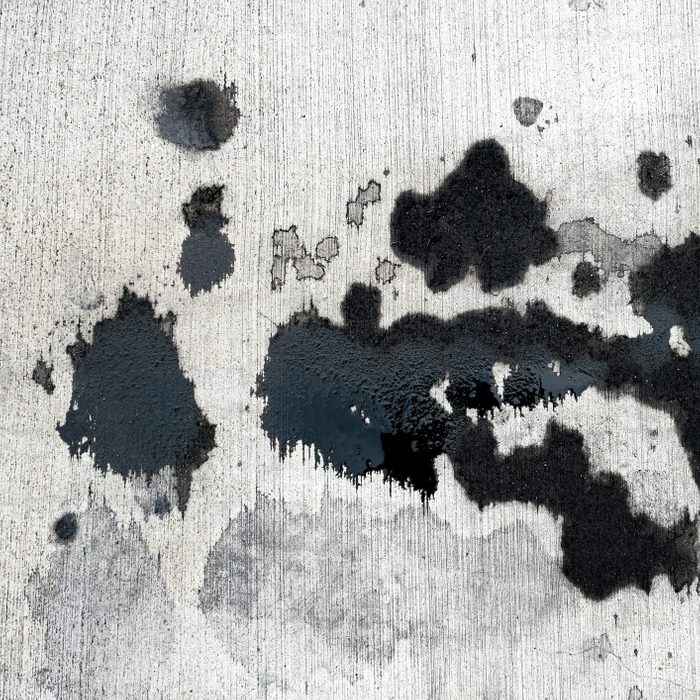 Stains of car oil drips and spots on concrete