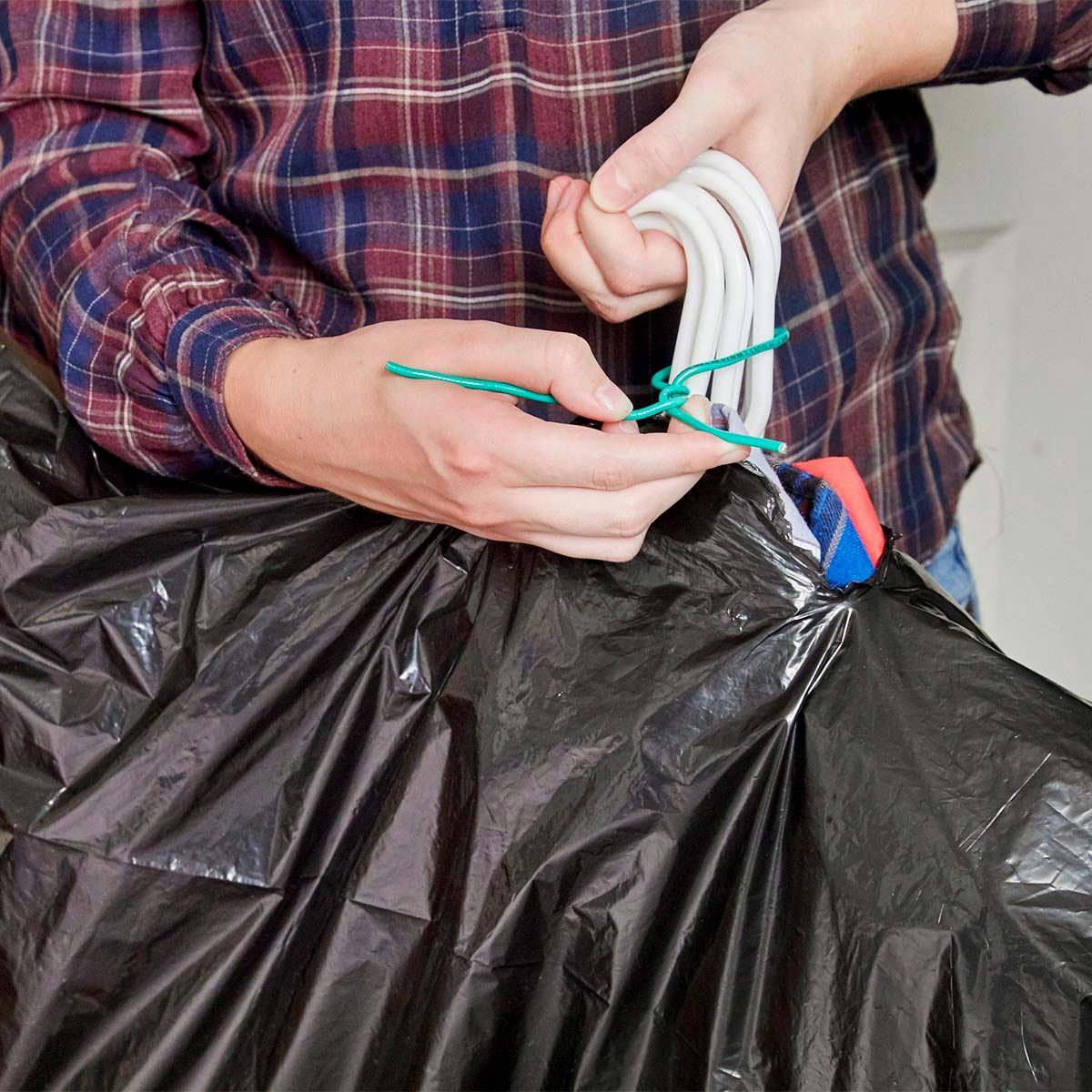 using a large black garbage bag with hangers as a clothes mover