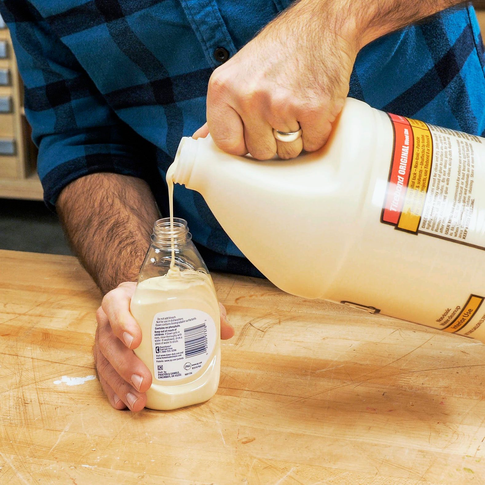 man pouring glue into a soap bottle