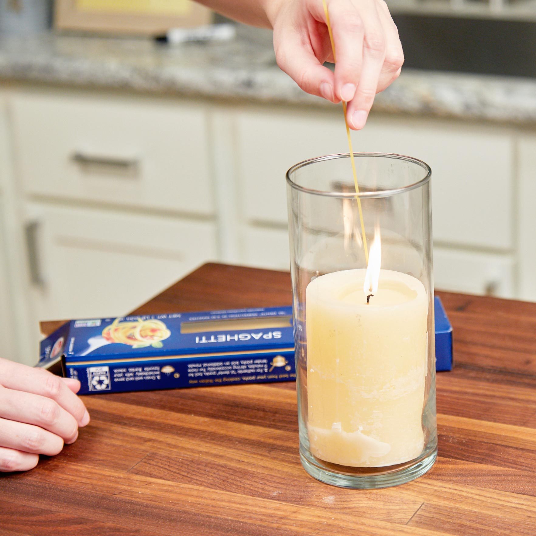 lighting a candle with a piece of uncooked spaghetti