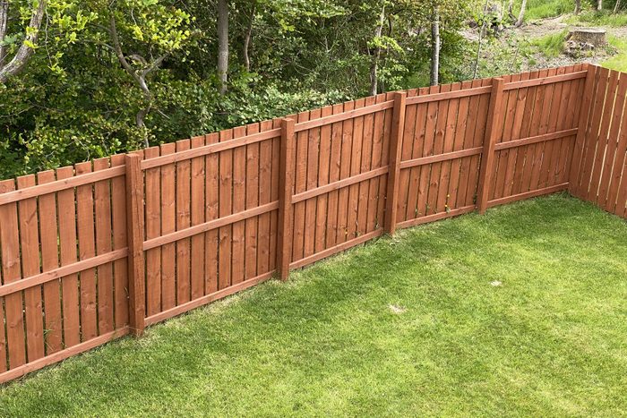 Wooden garden fence coated with medium oak colour paint