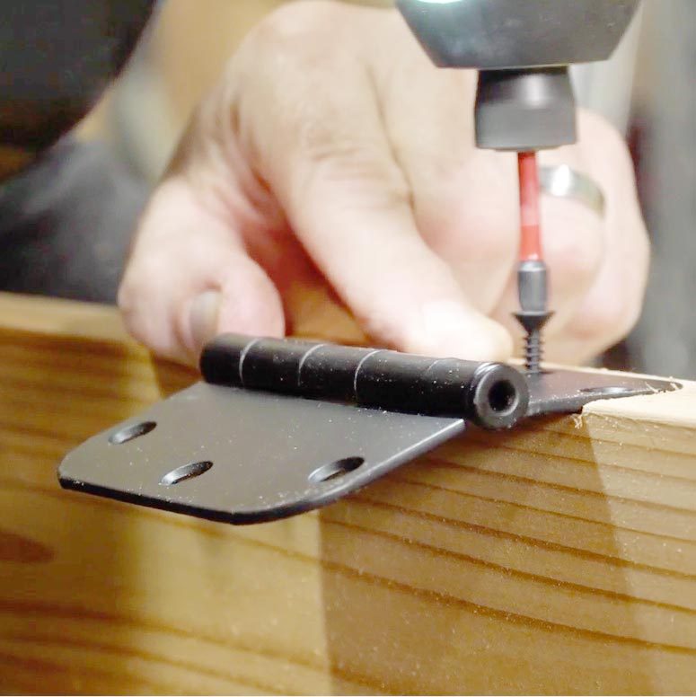 using a drill to attach the hinge