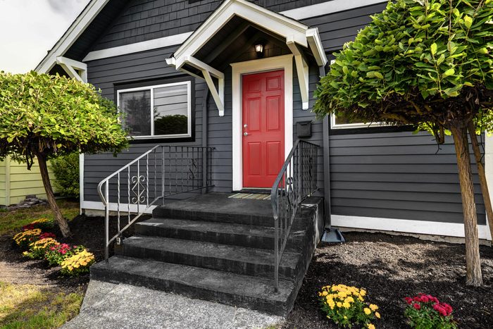 dark black house exterior with a red door