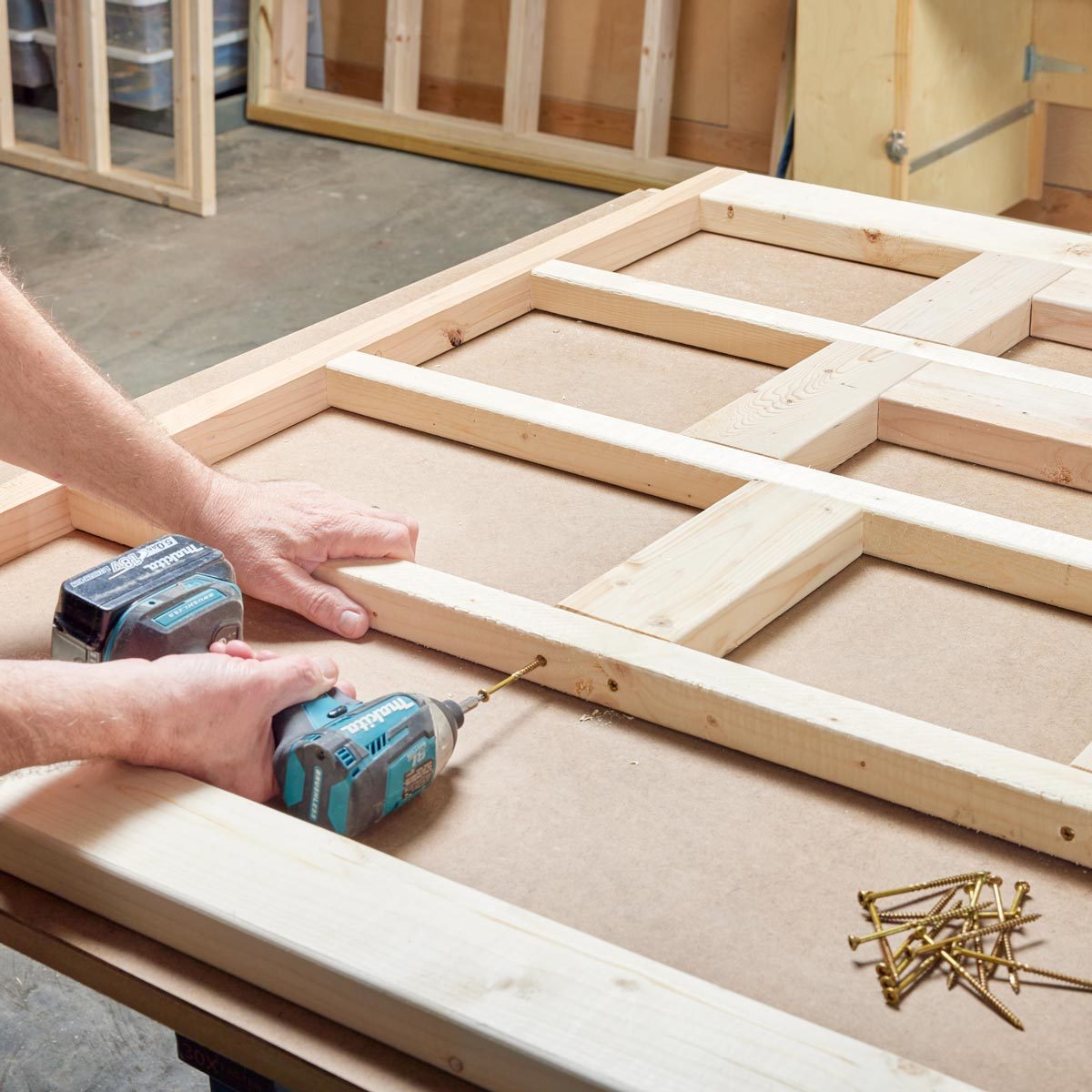 man using a drill to assemble braces for the sauna walls