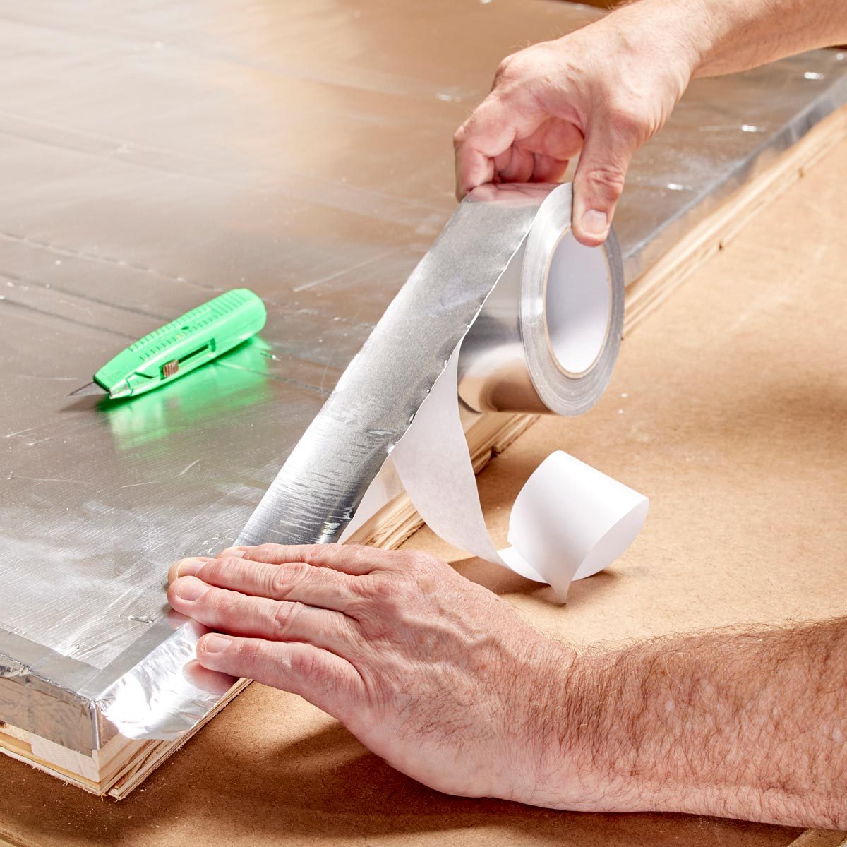 close up of hands Sealing the edges and seams with foil tape