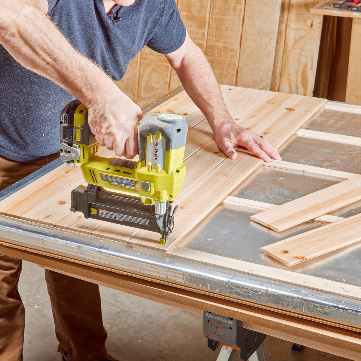 adding cedar planks of wood over the insulation on the sauna walls