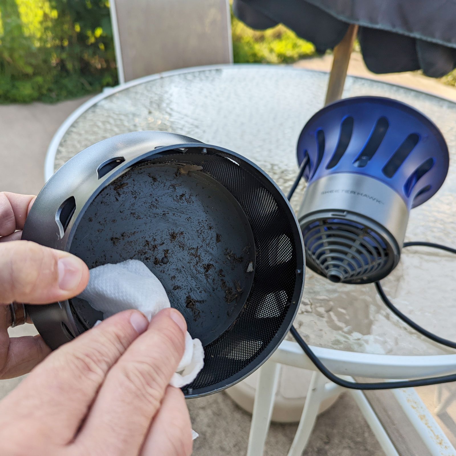 cleaning bugs from the bottom of the skeeter hawk fly trap