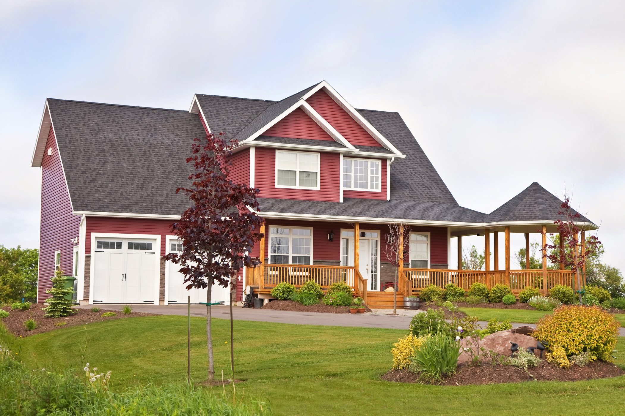 two story red Home exterior with a large grassy front yard