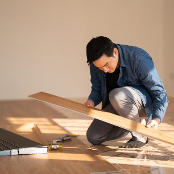 Carpenter is working on SPC flooring inside the house.