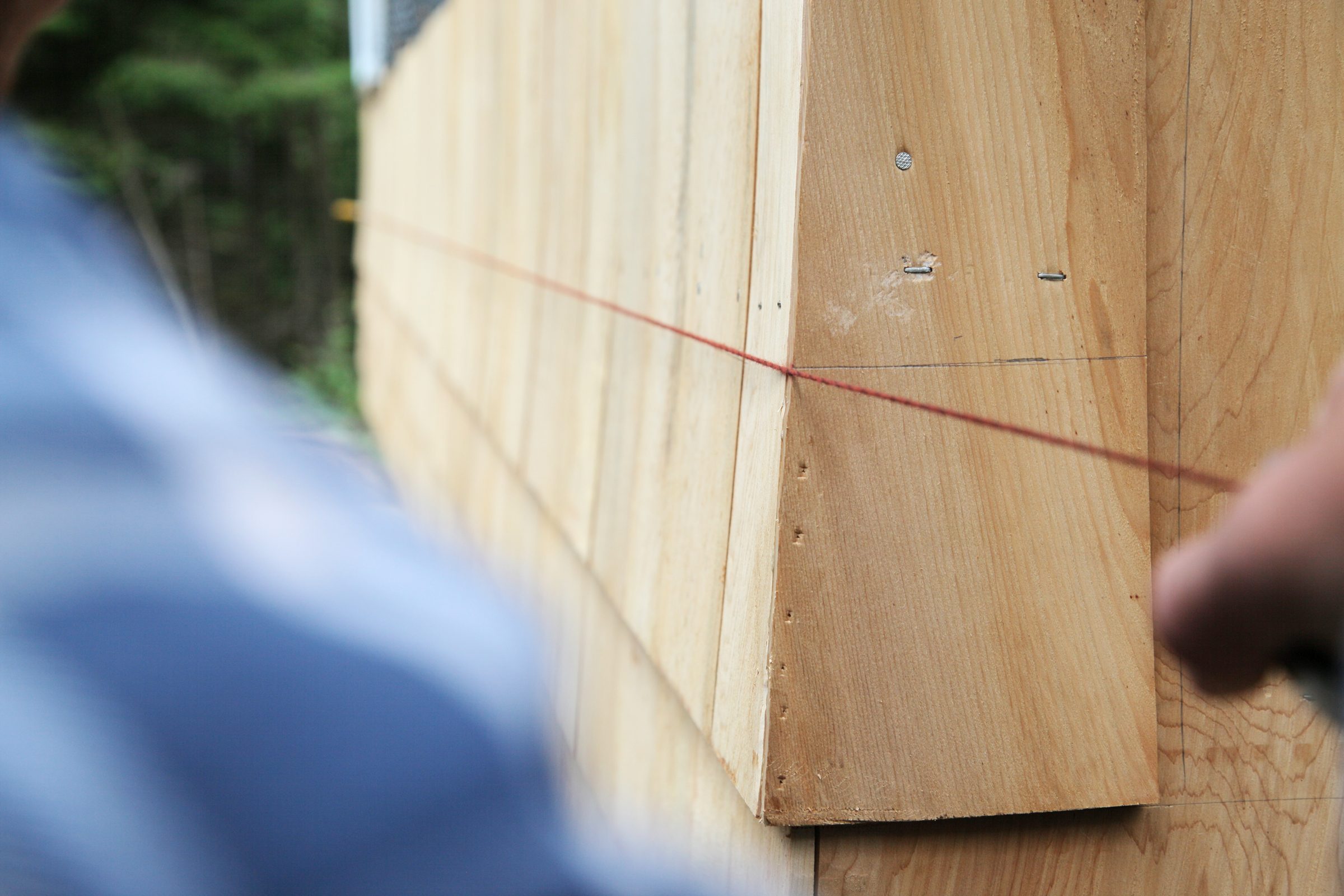 making a chalk line while doing a shingle project on the outside of a house