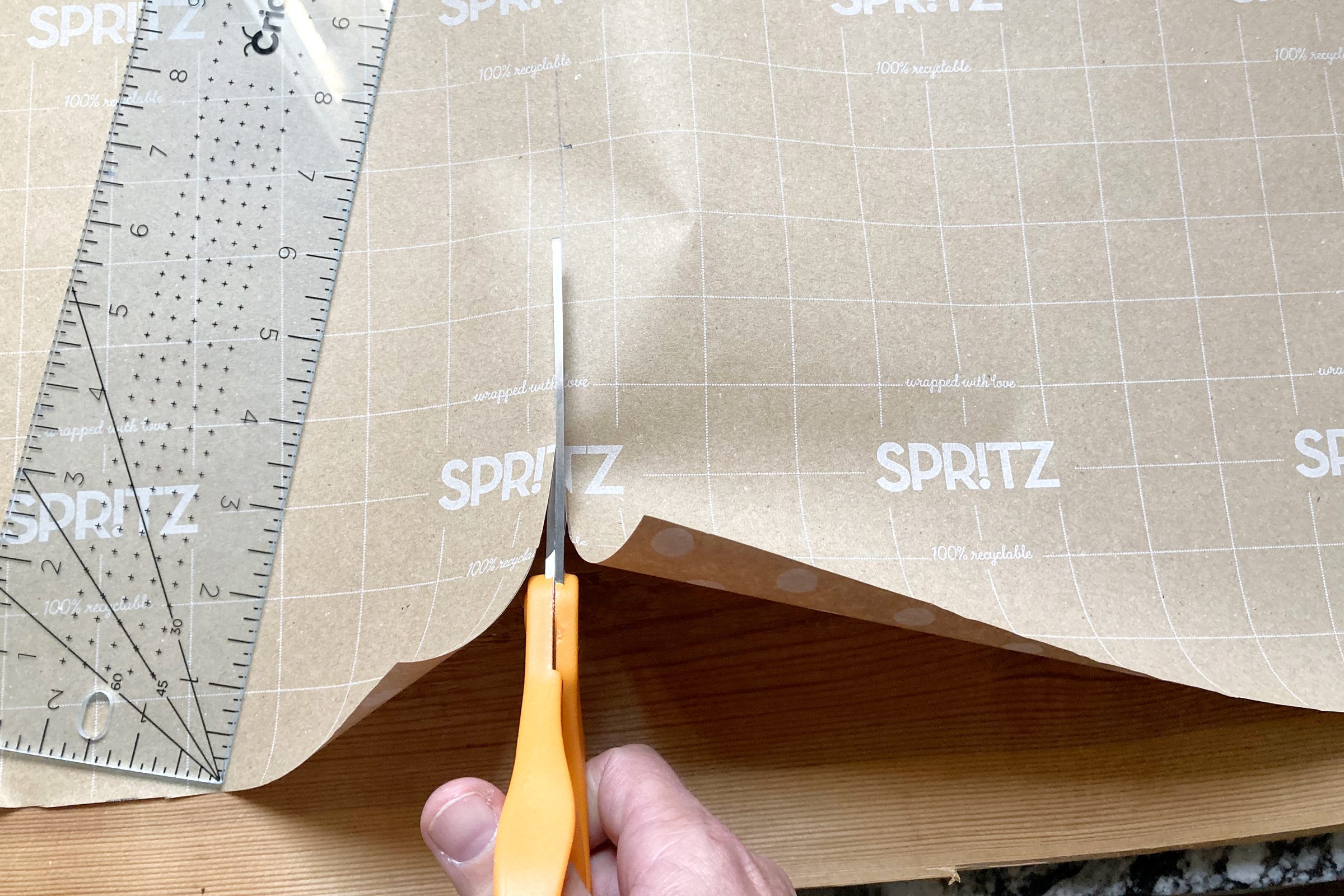 using scissors to cut wrapping paper for the christmas cracker