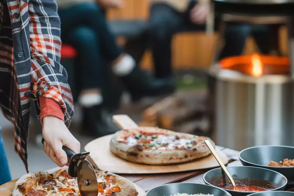 man cutting a pizza