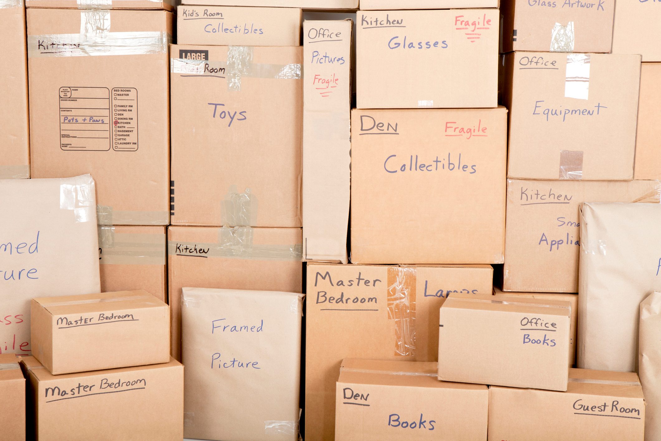 Moving boxes stacked wall to ceiling with labels on the side