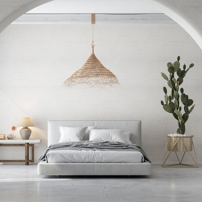 Bedroom Interior With Messy Bed, Side Table And Cactus Plant