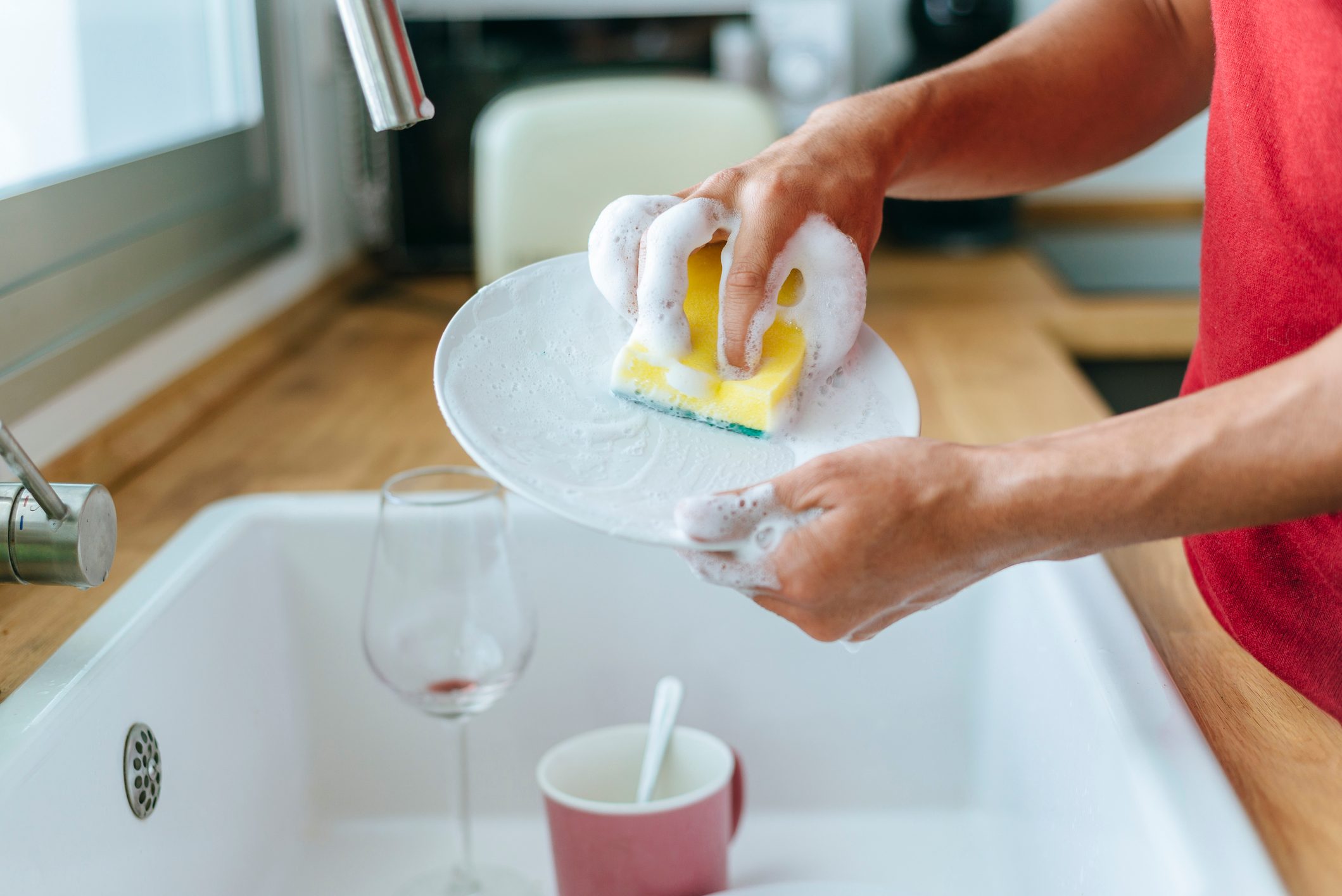 Close-up of man washing dishes in the sink