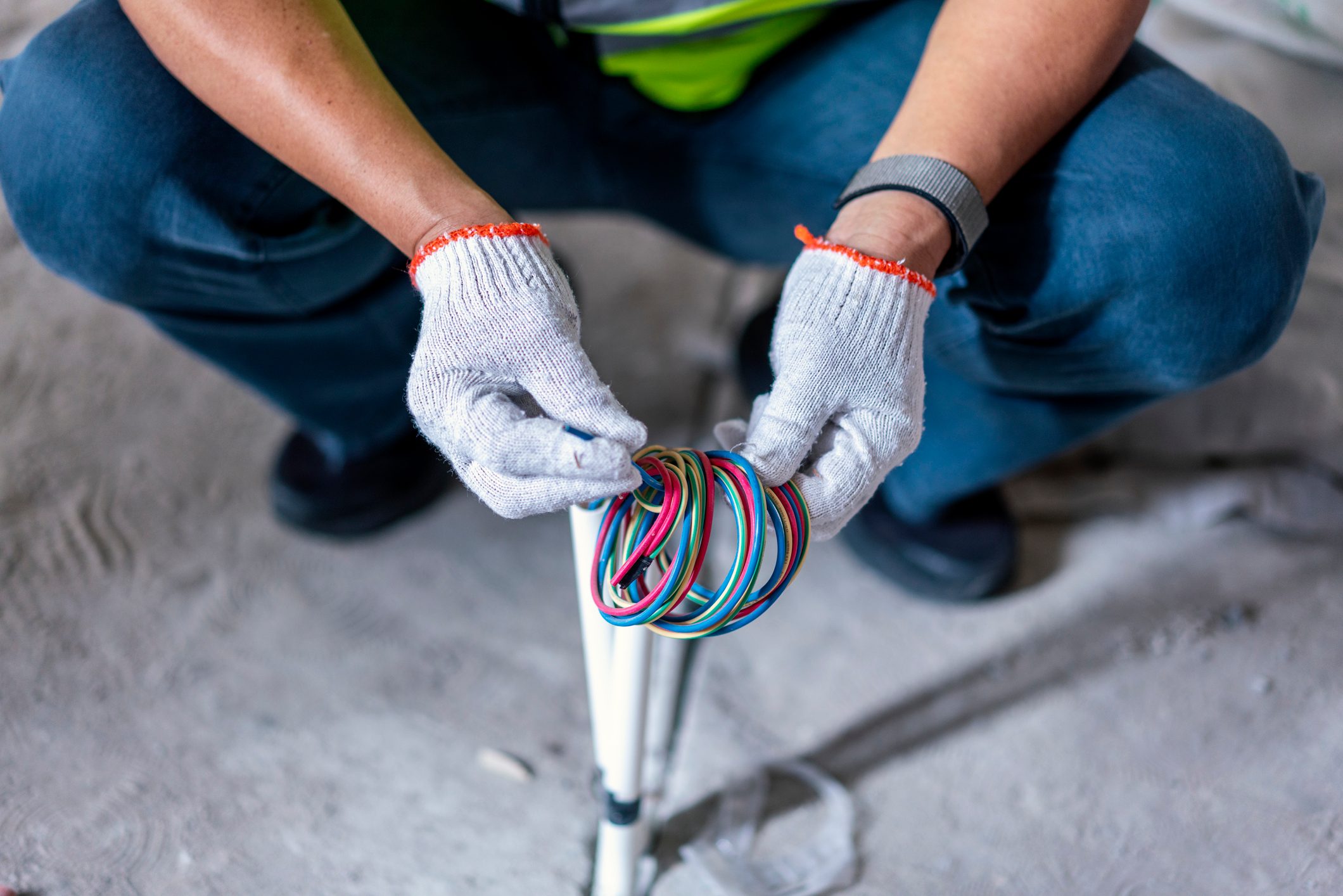 Close-up of construction worker repairing electric wire in construction site