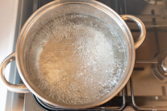 Boiling water inside a pot.Kitchen iron pot,top view,selective focus.