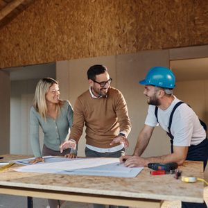 Happy couple talking about plans with their construction worker.