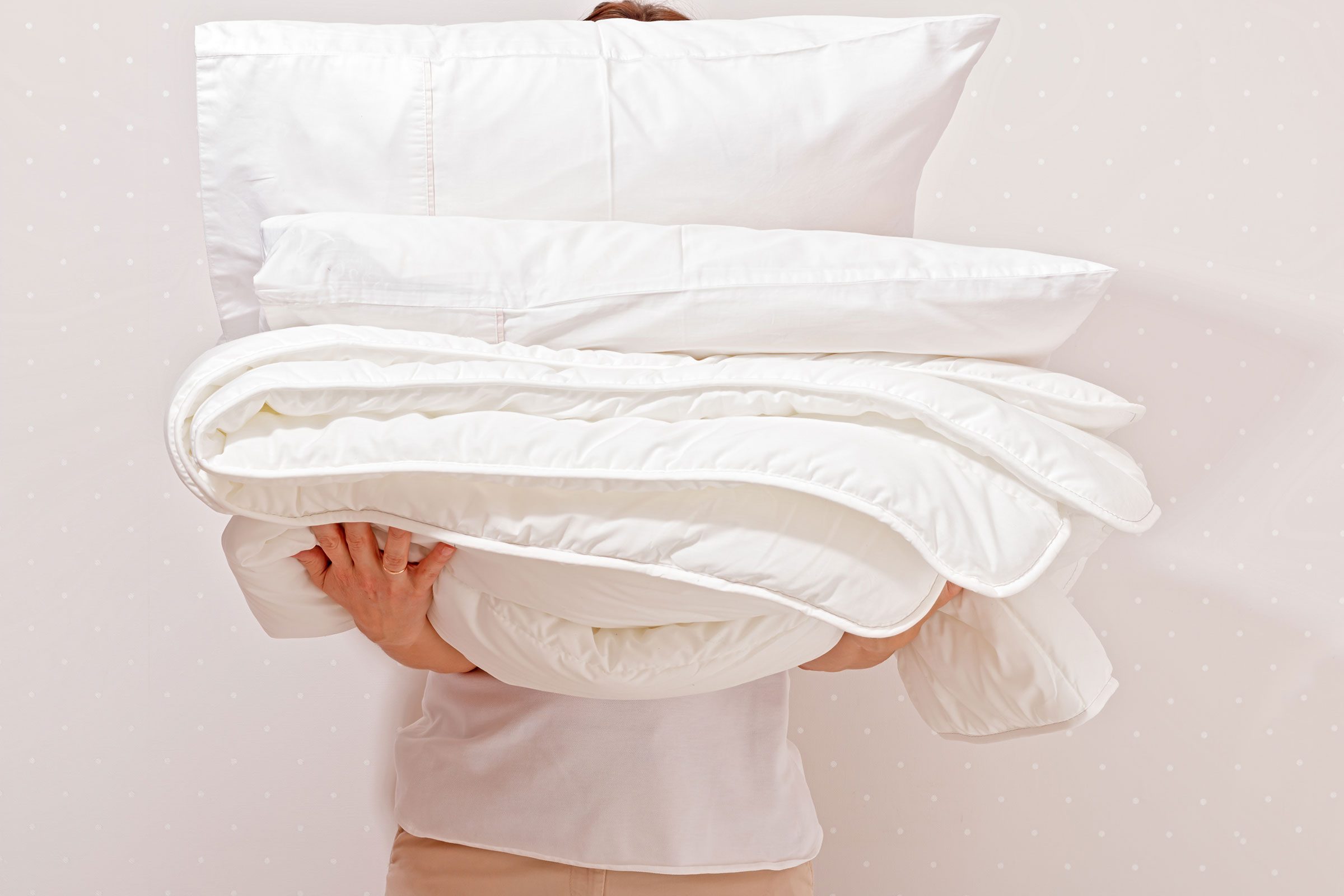 Woman Holding A Pile Of Bedding For Sleeping