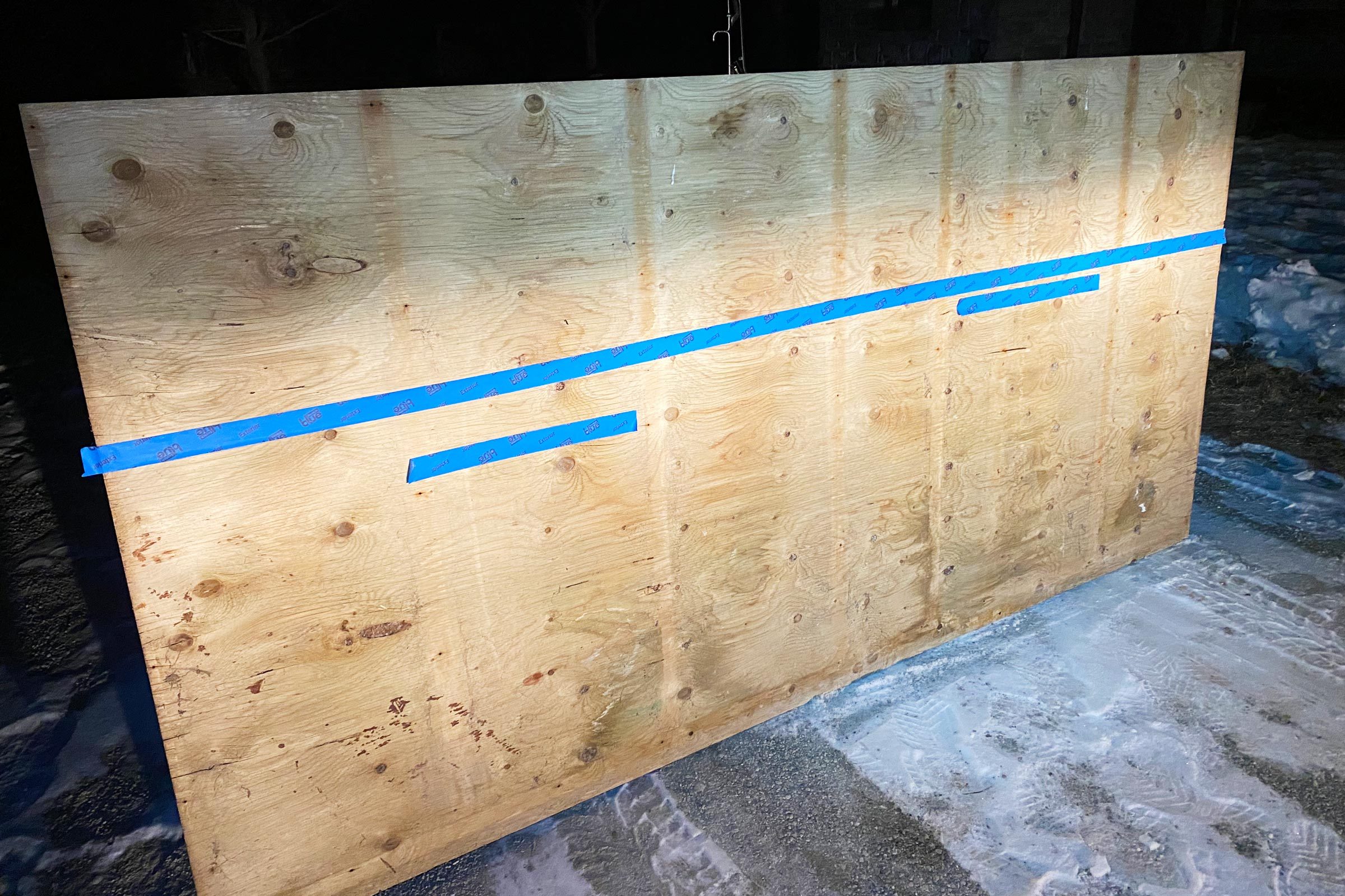 smaller pieces of tape below the large piece of tape on a piece of plywood