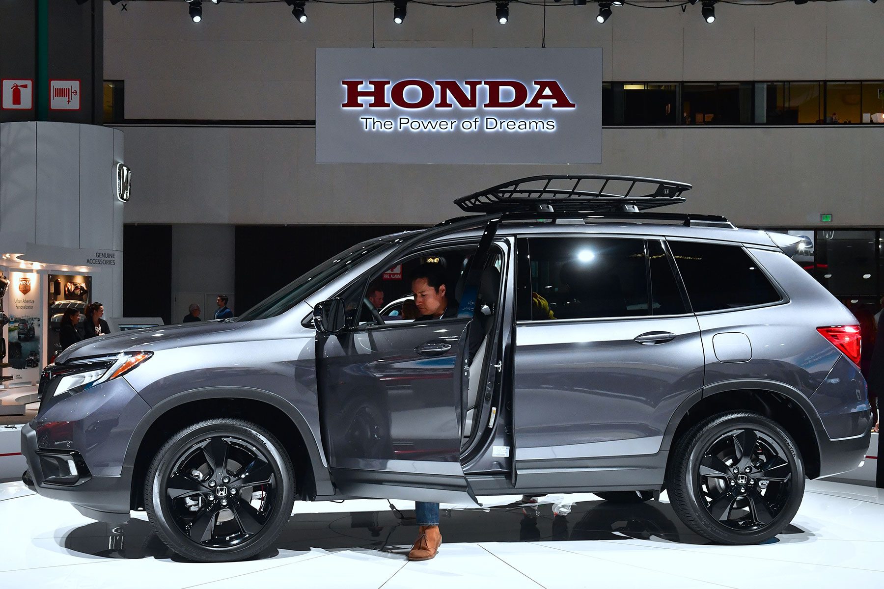 A woman checks out the drivers side of a 2019 Honda Passport AWD Elite on display at AutoMobility LA, the trade show ahead of the LA Auto Show