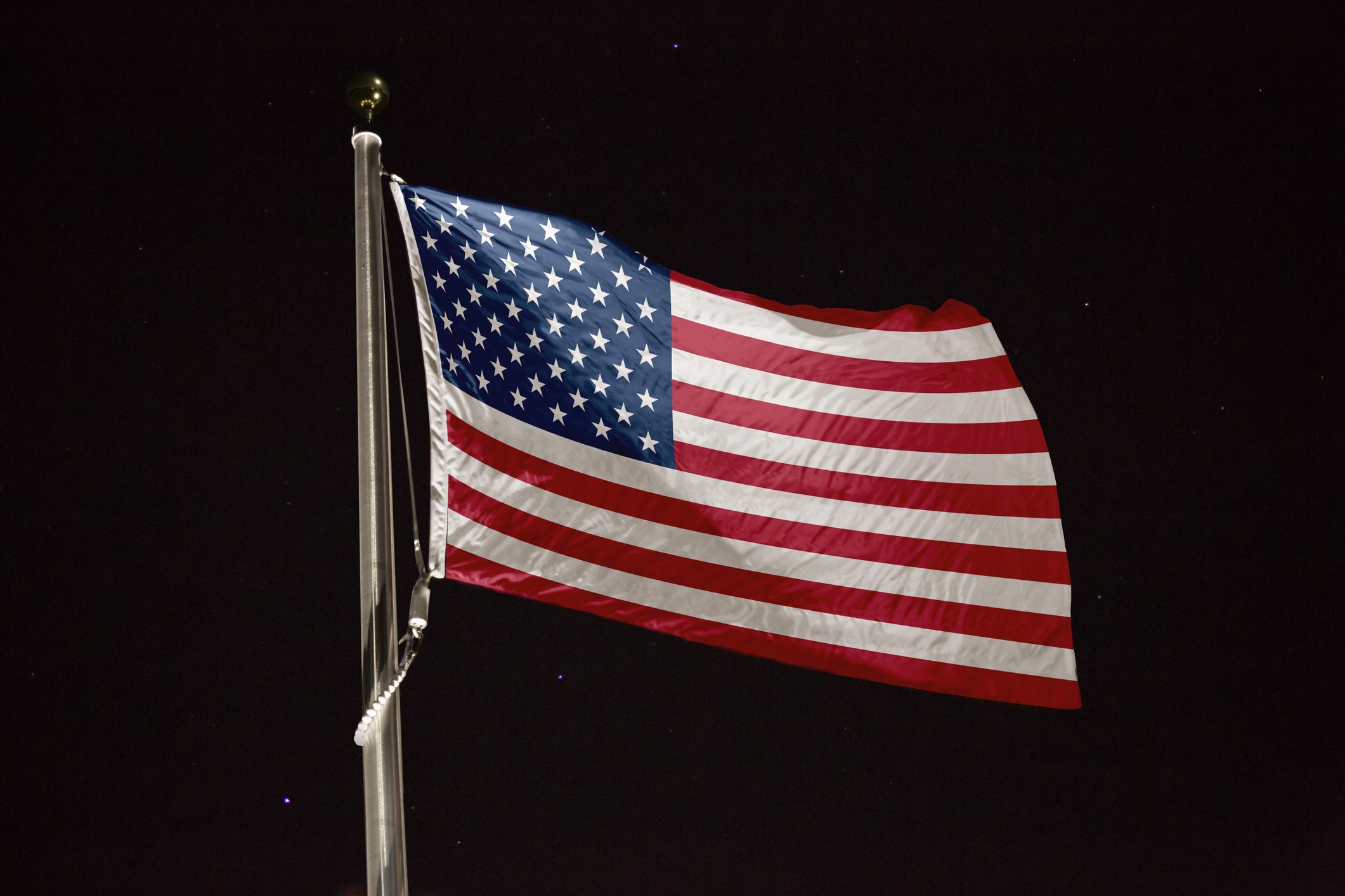 United States flag blowing in the wind at night