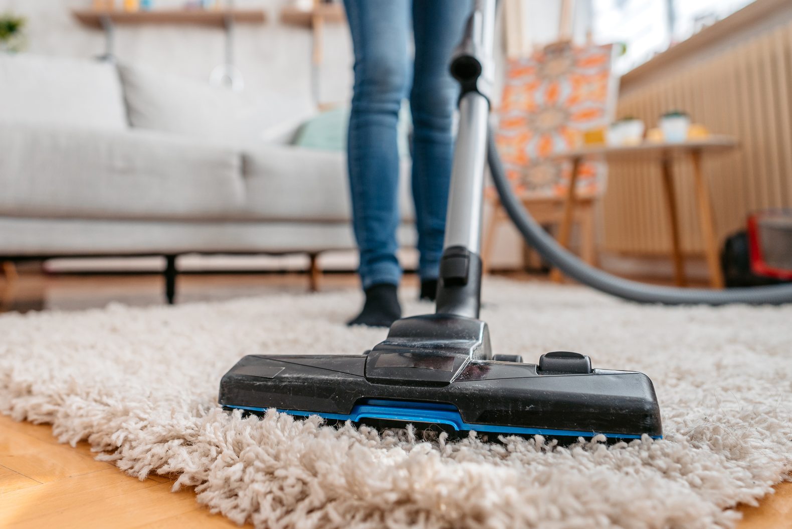 Young Woman Vacuuming Her Apartment