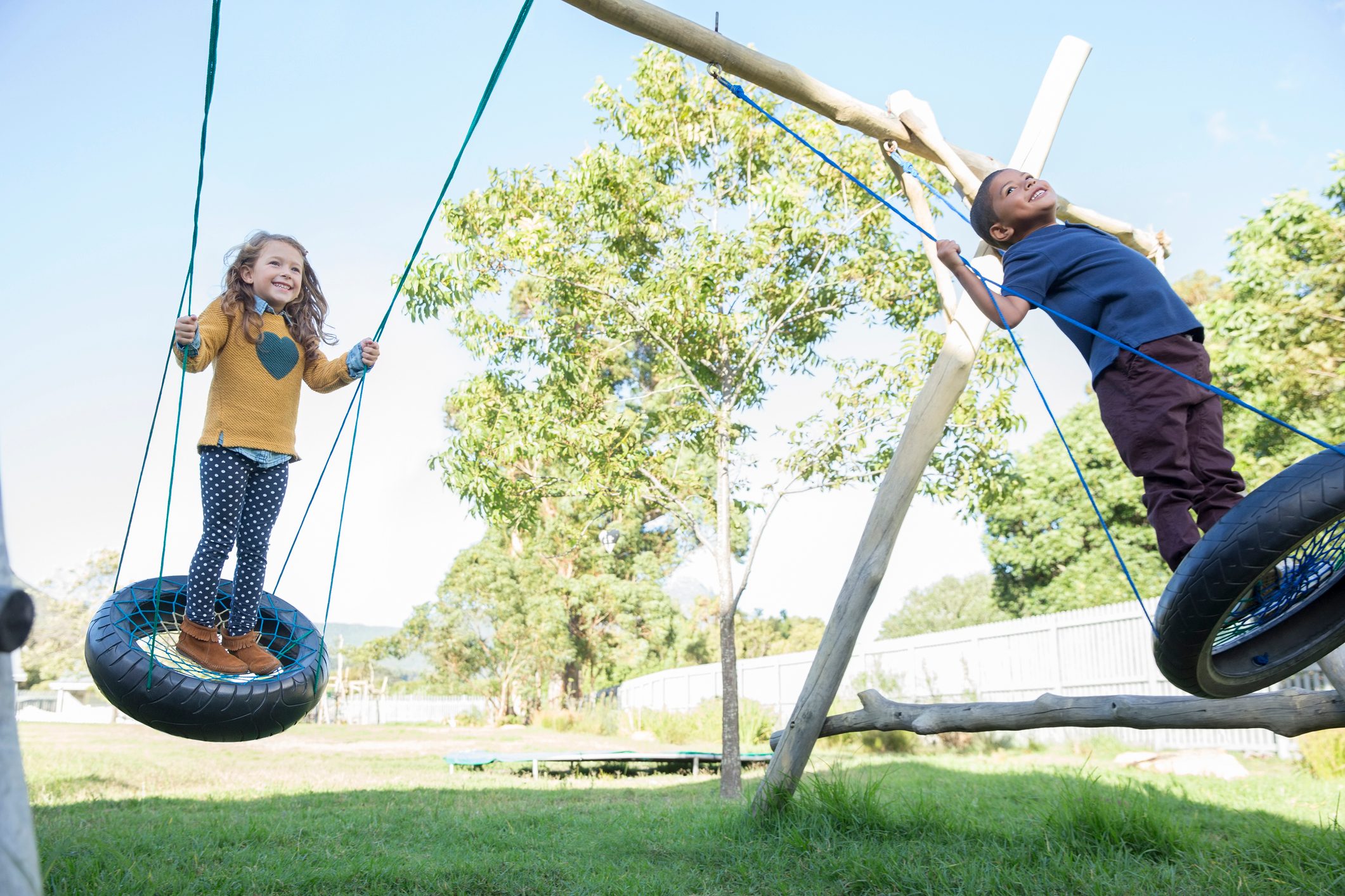 Children playing on tire swings