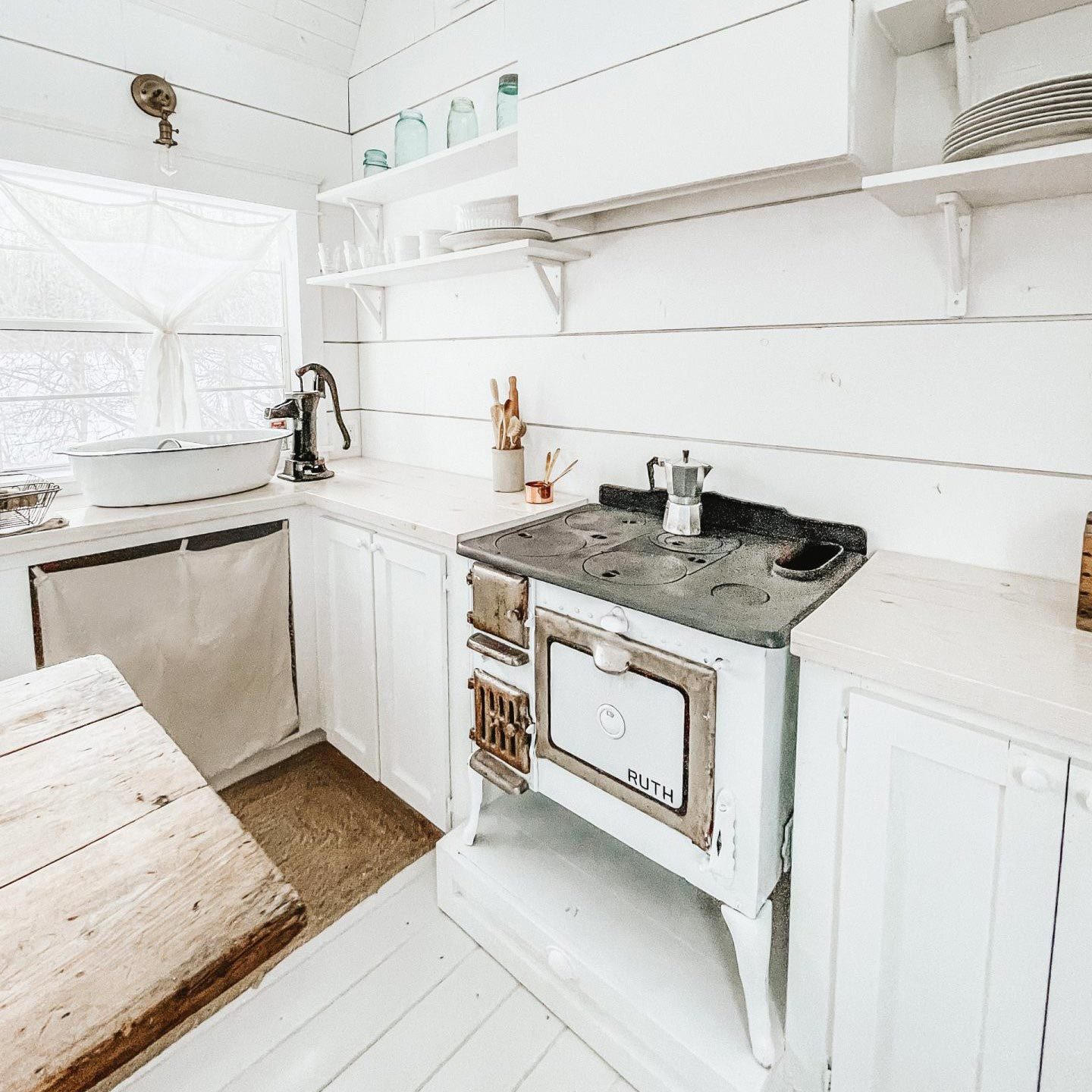 tiny home she shed with a white farmhouse style kitchen and stove