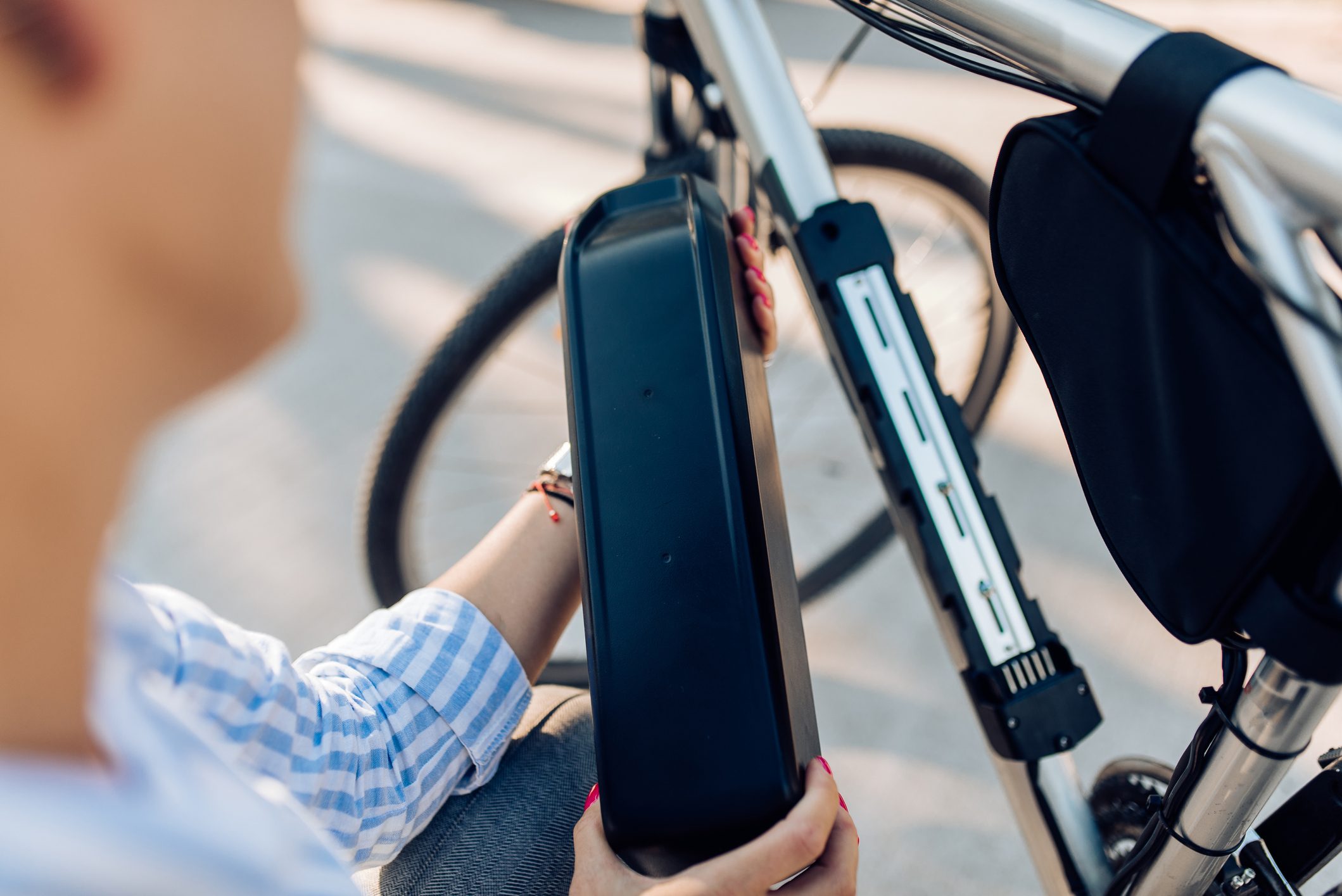 Unrecognizable woman changing batteries on her electric bicycle