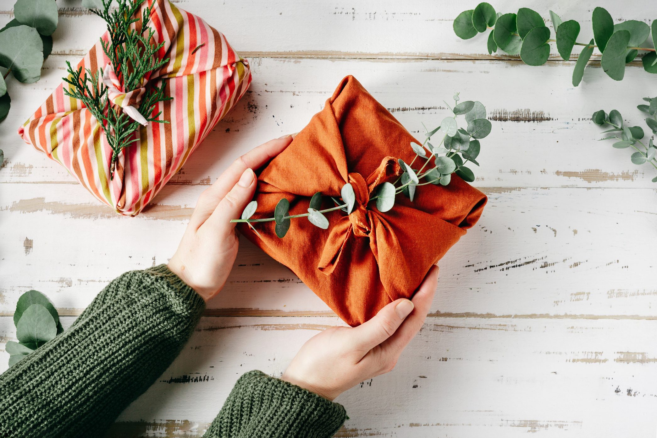 Wrapping a gift in eco friendly reusable fabric package furoshiki