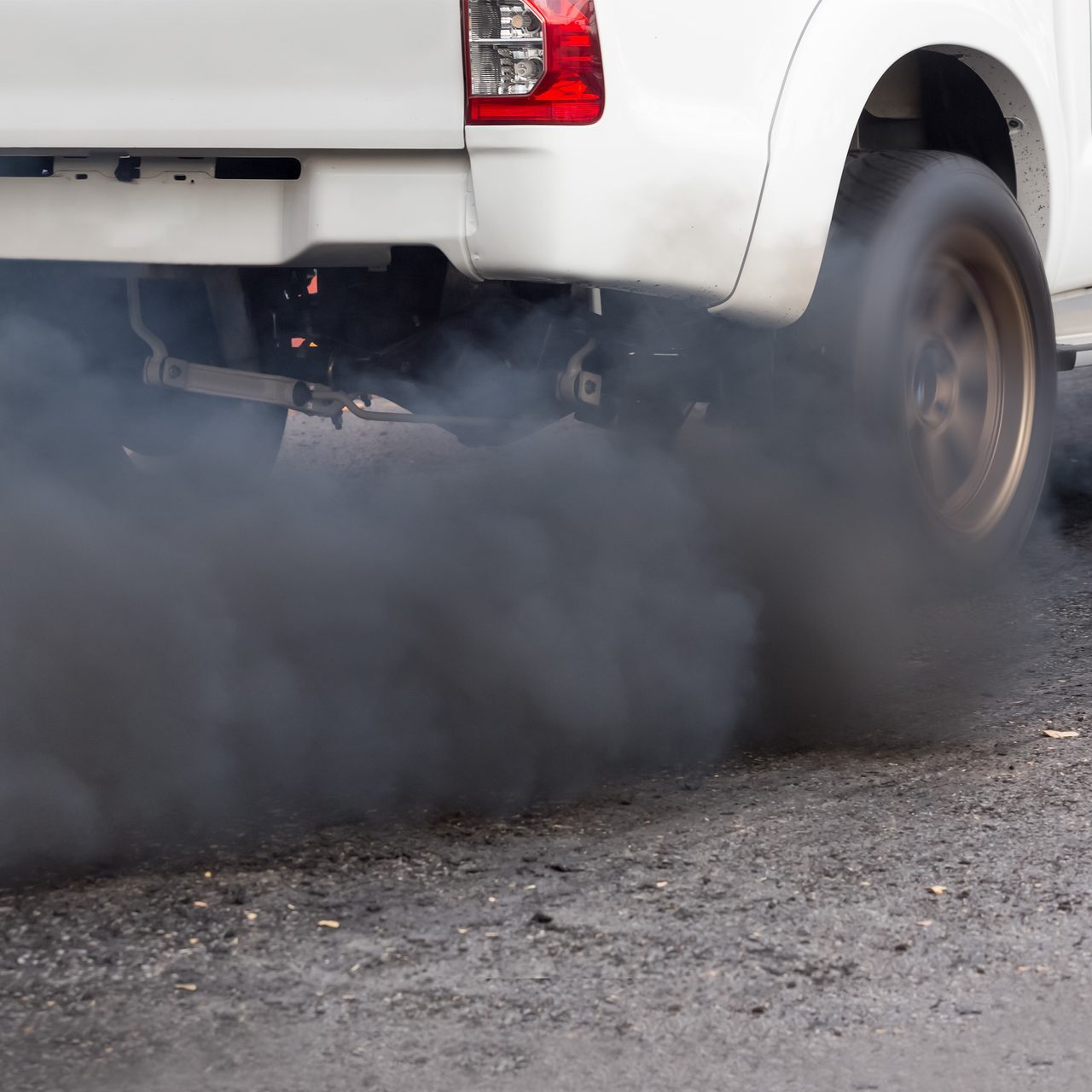 Air pollution from vehicle exhaust pipe on road