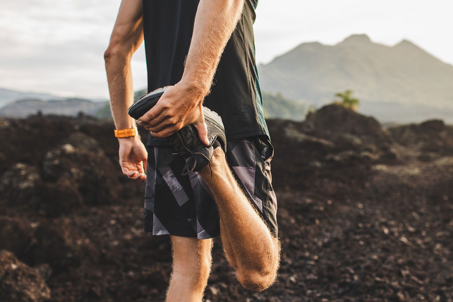 Runner stretching leg and feet and preparing for trail running outdoors