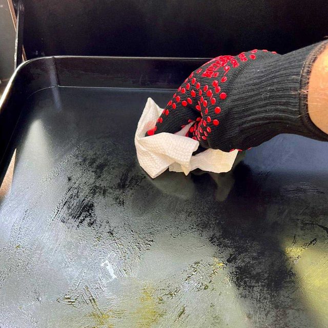 wiping grill while wearing a heat resistant glove