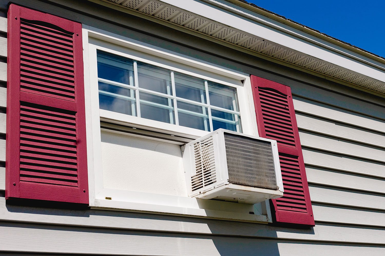 Air Conditioner in house window on a summer, sunny day