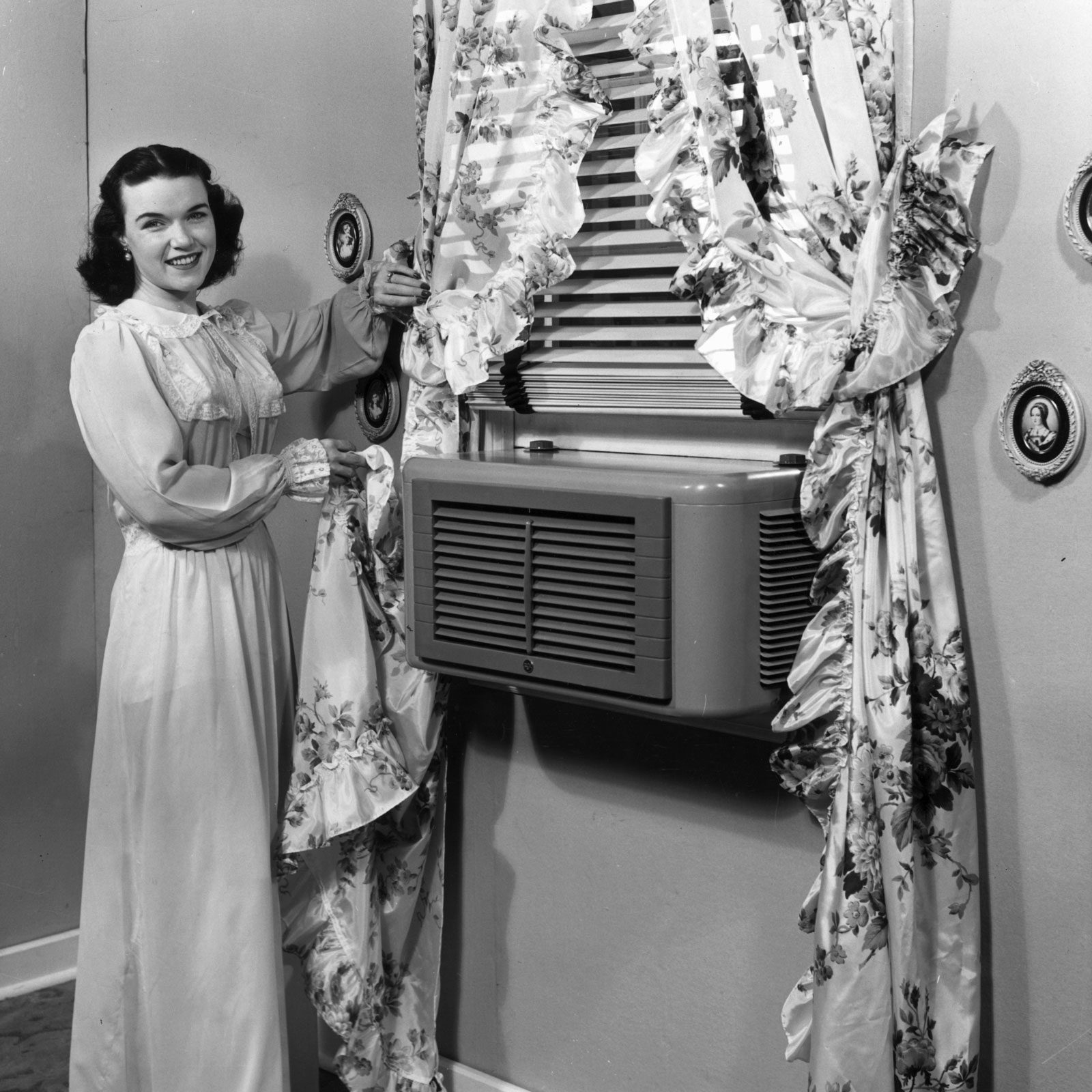 1940s Ac in a window with a woman standing next to it