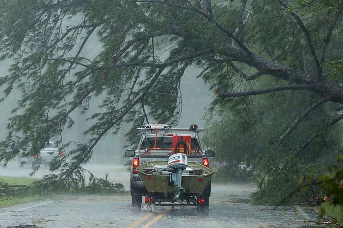 A volunteer rescue truck drives underneath a fallen tree that is suspended by power lines blown down by Hurricane Florence September 14, 2018 in New Bern, North Carolina