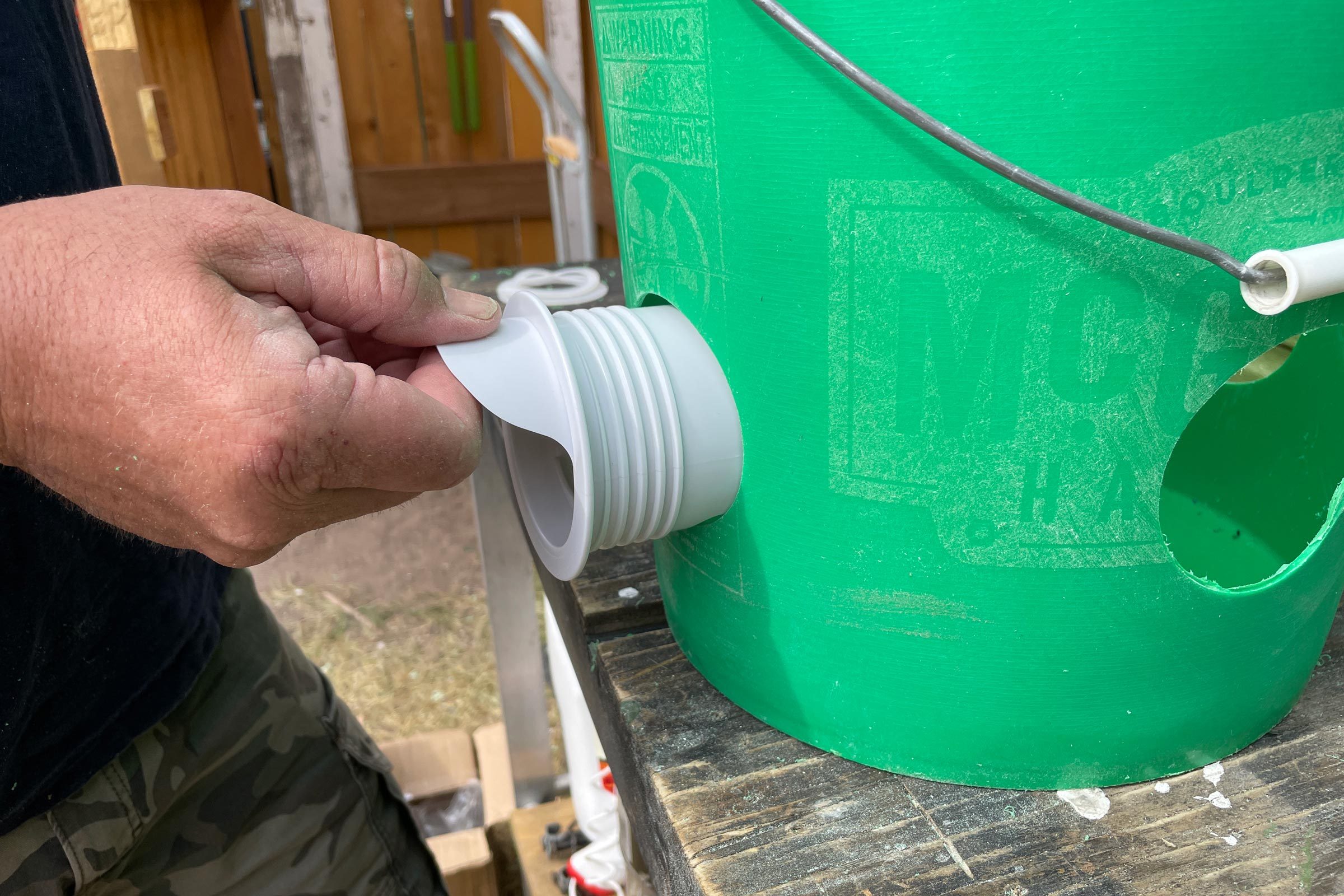 inserting feeder port into hole in side of bucket