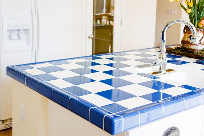 Modern kitchen interior with checkered white and blue tile.