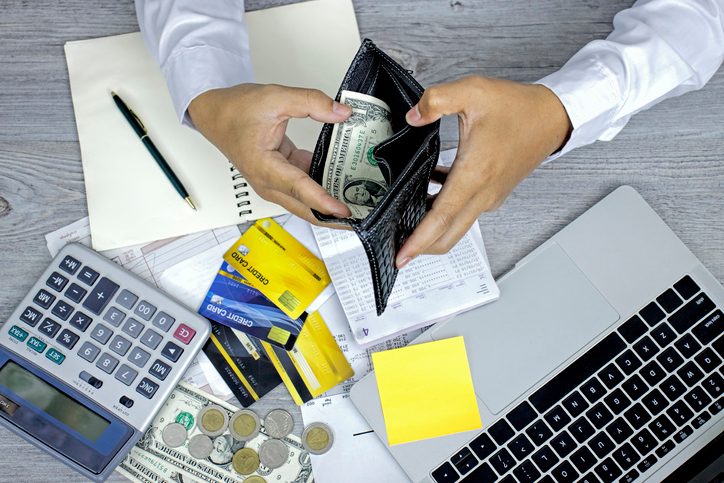 Man hands opening wallet at the table in managing home finances with credit cards, cash and bills