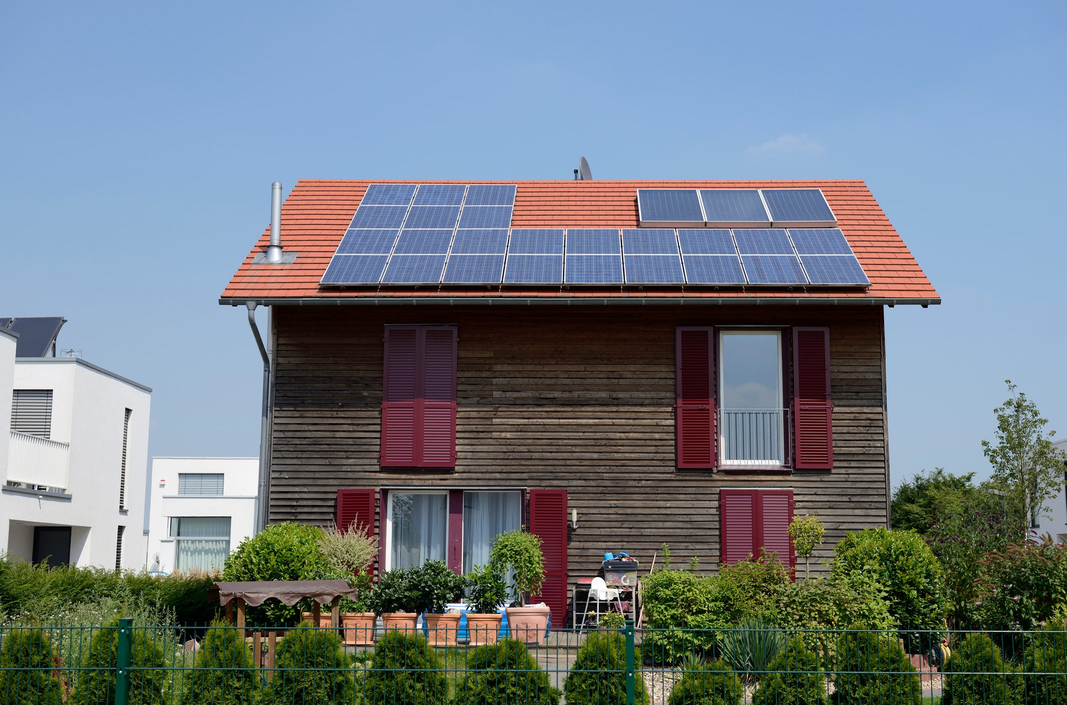 Family house with solar panels on the roof and garden