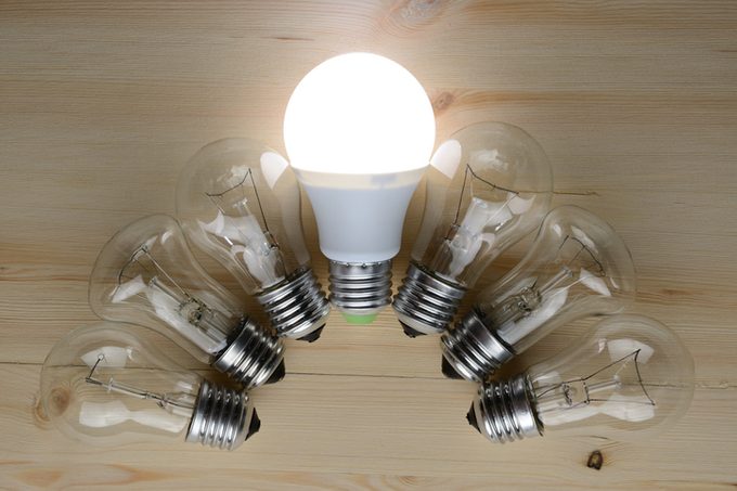 Glowing LED lamp including incandescent lamps on a wooden table