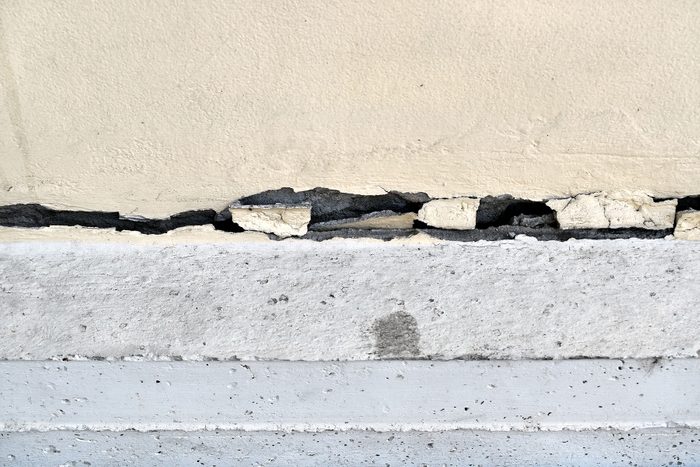 Large cracks are long crooked line on base of siding wall