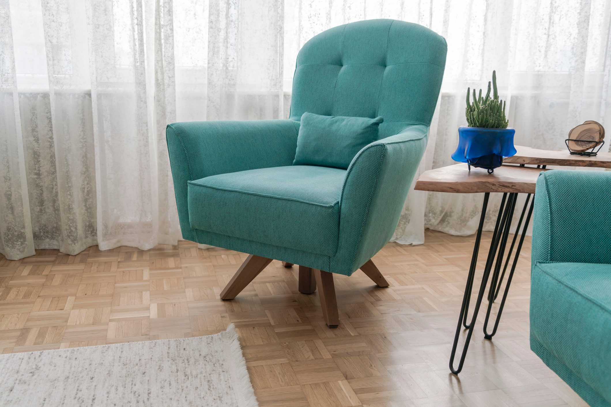 Turquoise blue armchairs on parquet floor in the living room