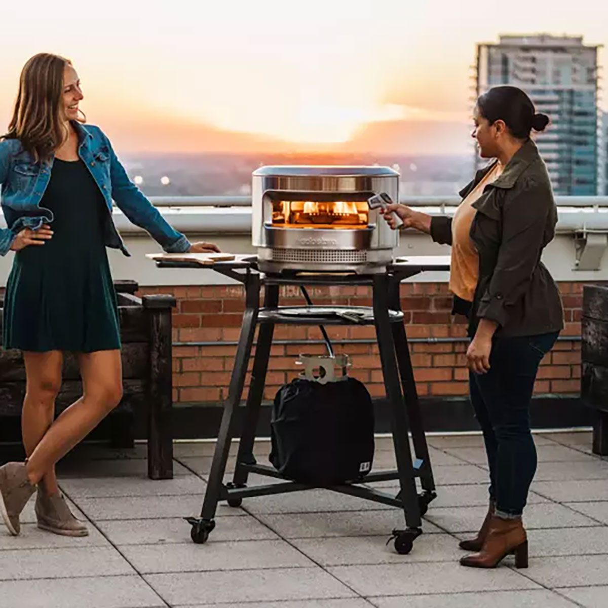 Two Ladies on the balcony with pizza oven on a stand