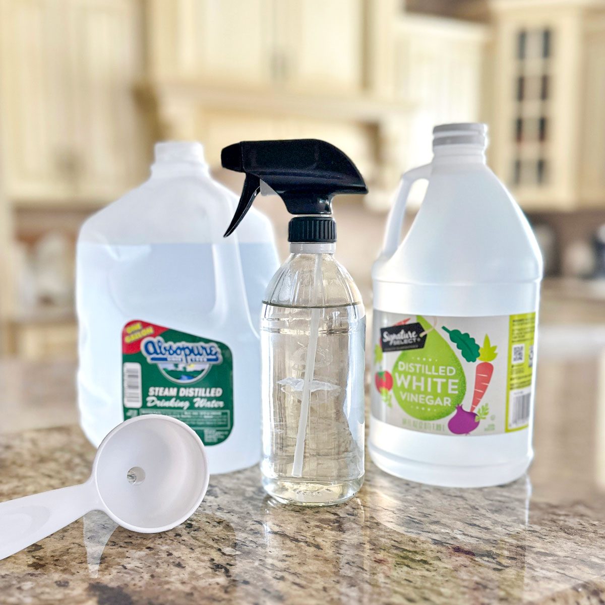 Diy Window Cleaner, white distilled vinegar bottle, Spray bottle, distilled water bottle and Plastic Funnel on Kitchen Countertop